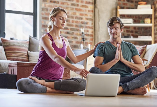 Couple discussing over laptop while doing yoga