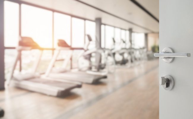 opened white door to fitness or gym room interior