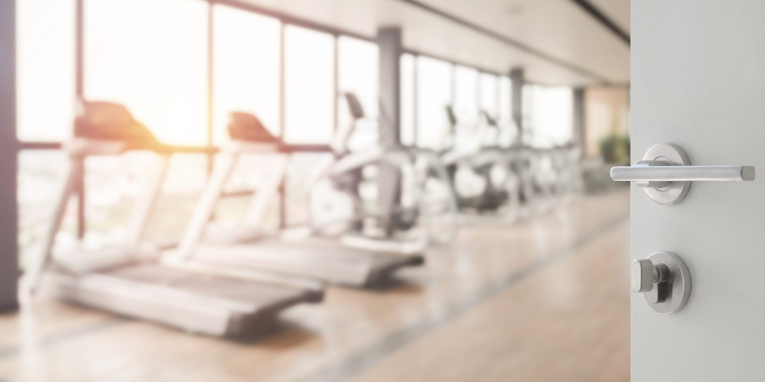 opened white door to fitness or gym room interior