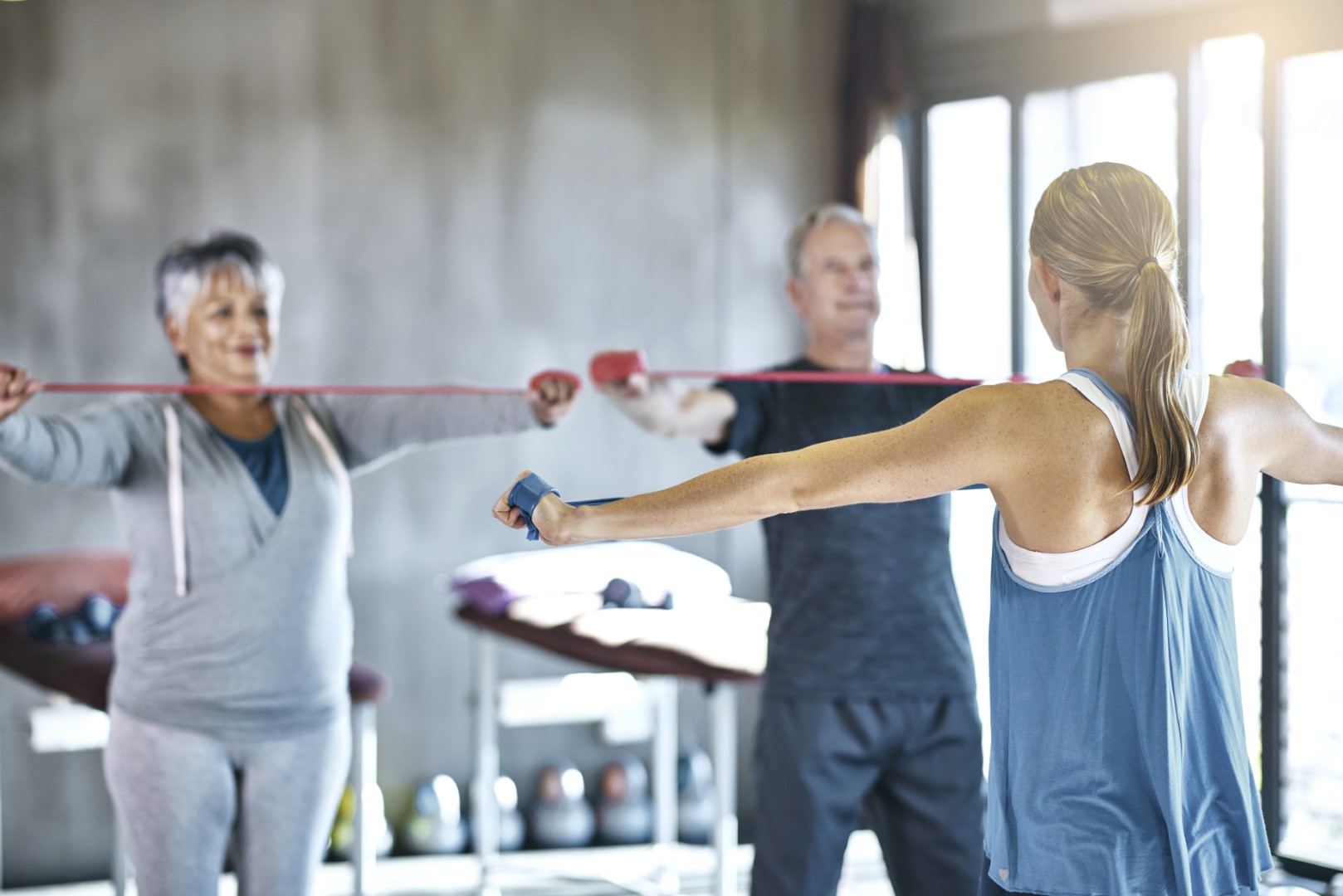 The senior years dont have to be the sedentary years. Shot of a senior man and woman using resistance bands with the help of a physical therapist.